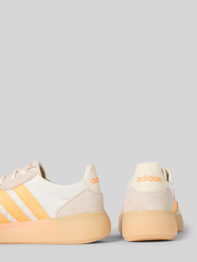 Produktfoto, Sneakersy z wiązaniem adidas Sportswear, mieszanka skóry, zaokrąglony czubek, detal z logo, fakturowana podeszwa, beżowo-pomarańczowy, wysokość obcasa 4 cm, wysokość cholewki 7 cm, szerokość cholewki 6 cm.