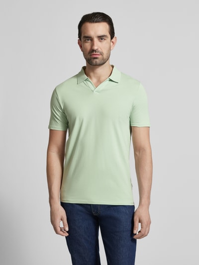 Männermodel trägt Slim Fit Poloshirt mit V-Ausschnitt von Lindbergh in hellgrünem Baumwoll-Elasthan-Mix, Ganzkörperansicht von vorne.