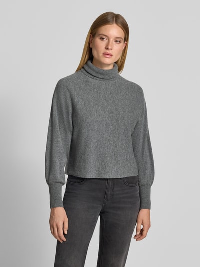 Frauenmodel trägt Regular Fit Pullover aus Woll-Mix mit Kaschmir-Anteil von HERZENS, grau meliert, Rollkragen, elastische Ärmelabschlüsse, Ganzkörperansicht von vorne.