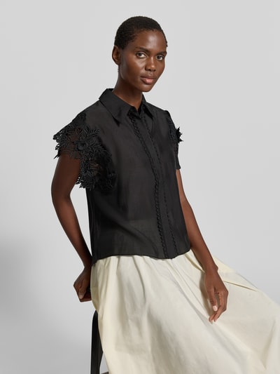 Frauenmodel trägt Regular Fit Bluse mit Spitzenbesatz Modell 'MOLLY' von Copenhagen Muse in Schwarz, Material-Mix mit Stretch-Anteil, Nahaufnahme Oberkörper. Rückenlänge 62 cm, Ärmellänge 10 cm, Hemdblusenkragen, verdeckte Knopfleiste, Damen Bluse.