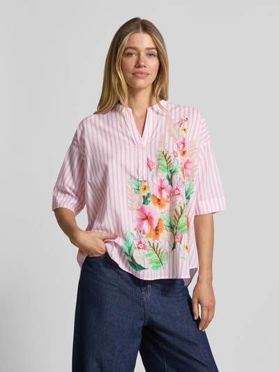 Frauenmodel trägt Relaxed Fit Bluse mit Motiv-Print und Tunikakragen von Emily Van den Bergh, rosa-weiß gestreift, reine Baumwolle, florales Muster, Ganzkörperansicht von vorne.