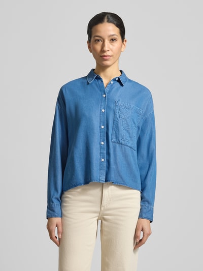 Frauenmodel trägt Boxy Fit Bluse aus Lyocell mit Label-Detail von Smith and Soul im Denim-Look mit Brusttasche, Ganzkörperansicht von vorne.