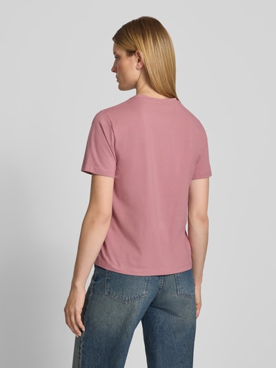 Frauenmodel trägt T-Shirt mit Rundhalsausschnitt Modell 'NORA' von VILA aus Baumwoll-Elasthan-Mix in Rosa, Regular-Fit, Rückenlänge 60 cm, Ganzkörperansicht Rückansicht.