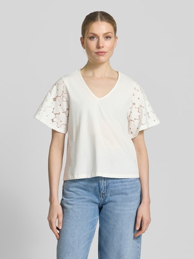 Frauenmodel trägt Regular Fit Blusenshirt aus reiner Baumwolle Modell 'VILLA' von Vero Moda, Optik: Unifarben, Spitzenbesatz, V-Ausschnitt, Ärmelform: Kurzarm, Materialverarbeitung: Jersey, Ganzkörperansicht von vorne.