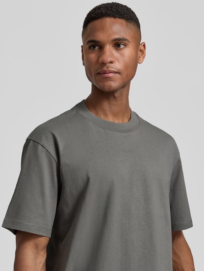 Männermodel trägt Regular Fit T-Shirt aus reiner Baumwolle Modell 'DAPOLINO' von HUGO in Optik: Unifarben, Label-Schriftzug, Nahaufnahme Oberkörper.