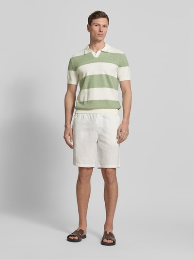 Męski model nosi Slim Fit Poloshirt aus Baumwoll-Mix in Strick-Optik von OLYMP Level Five, pasy zielono-białe, krótkie rękawy, krój slim fit, bawełniany miks, kołnierzyk, widok całej sylwetki z przodu.