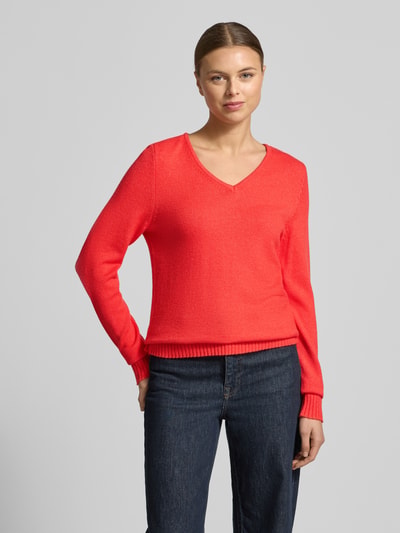 Frauenmodel trägt Regular Fit Longsleeve aus Viskose in Strick-Optik Modell 'Viril' von Vila, kräftiges Rot, V-Ausschnitt, Ganzkörperansicht von vorne.