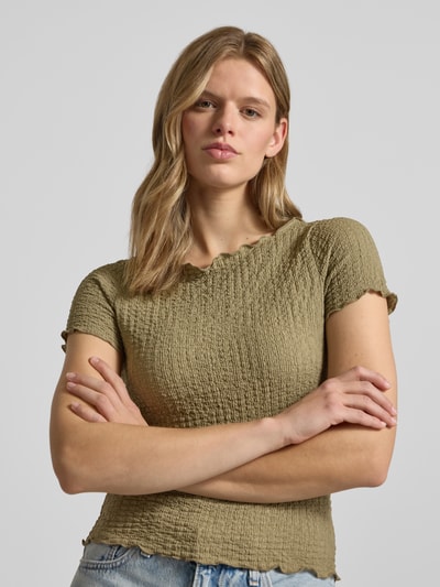 Frauenmodel trägt Slim Fit T-Shirt mit Strukturmuster Modell 'Alora' von Noisy May in Olivgrün, U-Boot-Ausschnitt, Nahaufnahme Oberkörper.
