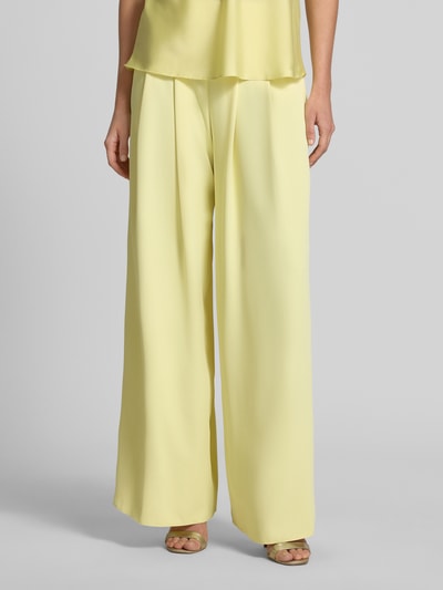 Frauenmodel trägt Stoffhose mit französischen Eingrifftaschen von Rinascimento in Hellgelb, Wide Leg Fit, Material-Mix, Nahaufnahme Unterkörper.