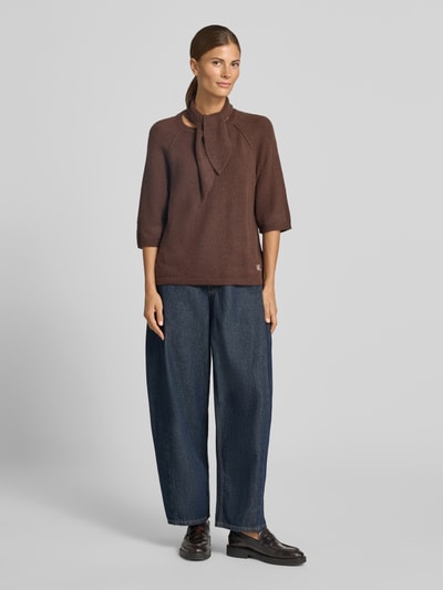Frauenmodel trägt Strickshirt mit Schal und Rundhalsausschnitt von Smith and Soul in Braun mit geradem Schnitt, Halbarm, Jeans, Ganzkörperansicht von vorne. Elastischer Material-Mix mit Alpaka-Anteil, Logo-Stitching sichtbar, Rückenlänge 59 cm, Ärmellänge 47 cm.