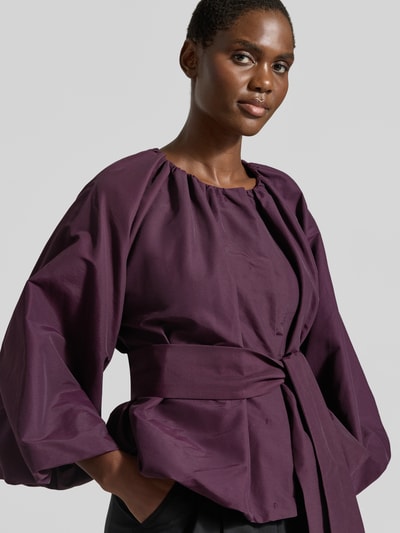 Vrouwenmodel draagt blouse met lange mouwen in diepe paarstint met wijde mouwen en strikceintuur, Relaxed Fit Blazer aus Baumwoll-Mix van Rich & Royal, Dames Langarmbluse, close-up bovenlichaam.