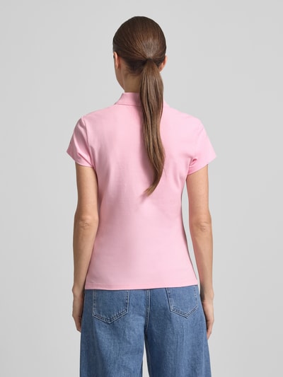 Frauenmodel trägt Slim Fit Poloshirt aus Baumwoll-Mix von Tommy Hilfiger, Optik: Unifarben in Rosa, Logo-Stitching, Piqué, Kurzarm, Ganzkörperansicht Rückansicht.