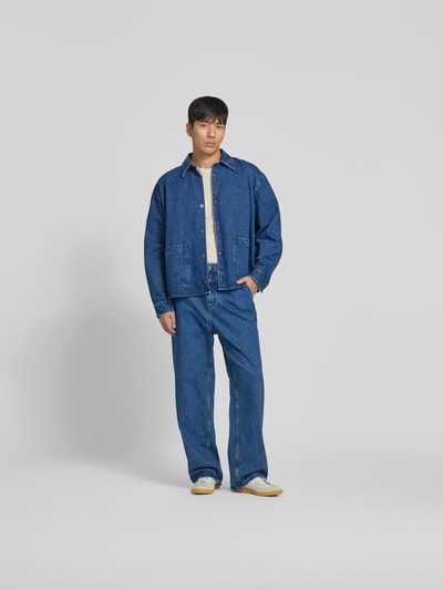 Männermodel trägt Straight Fit Jeans mit Logo-Detail von WON HUNDRED aus Reine Baumwolle in Blau, Ganzkörperansicht von vorne. Innenbeinlänge 78 cm, Bundweite 45 cm, Eingriff- und Gesäßtaschen, Knopf- und Reißverschluss.