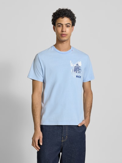 Männermodel trägt Regular Fit T-Shirt mit Logo-Print von Replay in Hellblau, reine Baumwolle, Statement-Print, Rundhalsauschnitt, Ganzkörperansicht von vorne.