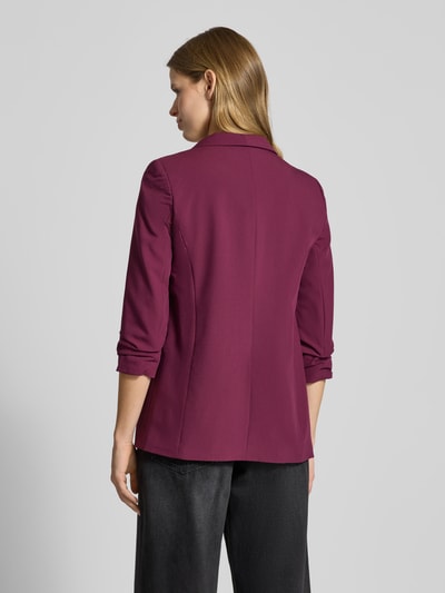 Modelka nosi Blazer mit Schalkragen od PIECES, luźny krój, jednolity kolor, szalowy kołnierz, zakładane fałdy, widok całej sylwetki z tyłu.