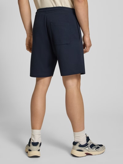 Männermodel trägt Shorts mit Strukturmuster von REVIEW in Dunkelblau aus Baumwoll-Mix, Regular-Fit, elastischer Bund, Ganzkörperansicht Rückansicht.