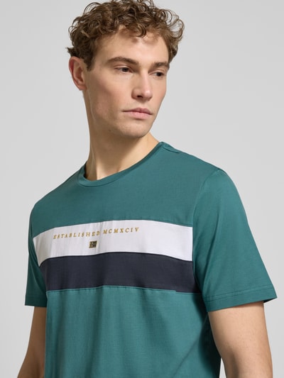 Männermodel trägt Regular Fit T-Shirt mit Rundhalsausschnitt von Christian Berg Men, Baumwolle, Statement-Print, Nahaufnahme Oberkörper.