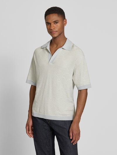 Męski model nosi Relaxed Fit Poloshirt mit V-Ausschnitt Modell 'LAURENZZO' od Drykorn, bawełniany miks w jasnoszary wzór, całkowity widok z przodu.