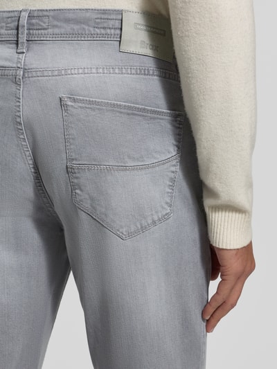 Männermodel trägt Straight Fit Jeans mit 5-Pocket-Design Modell 'Cadiz' von Brax, Baumwoll-Lyocell-Mix, Label-Detail, Detailaufnahme Rückansicht.