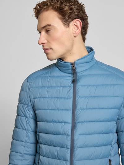 Männermodel trägt Steppjacke mit Reißverschluss von MCNEAL in Hellblau, Stehkragen, Regular Fit, Nahaufnahme Oberkörper.