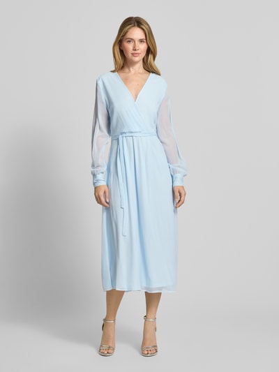 Frauenmodel trägt Midikleid mit Taillenband Modell 'FALIA' von Vila in Hellblau, Wickel-Optik, V-Ausschnitt, semitransparente Ärmel, blickdichter Unterrock, taillierte Passform, Rücklänge 127 cm, Brustweite 47 cm, Ärmellänge 66 cm, Ganzkörperansicht von vorne.