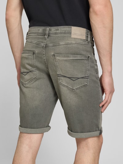 Männermodel trägt Bermudas im 5-Pocket-Design mit aufgeschlagenem Saum von Christian Berg Men aus grauem Baumwoll-Mix, Ganzkörperansicht Rückansicht.
