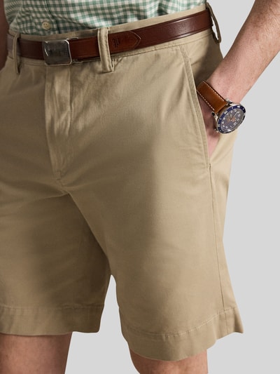 Mężczyznamodel nosi Straight Fit Chinoshorts aus Baumwoll-Mix von Polo Ralph Lauren, efekt: jednolity kolor, krój straight fit, detal z logo, szlufki na pasek, zapięcie na guzik i zakryty zamek błyskawiczny, kieszeń z tyłu, wpuszczane kieszenie, mieszanka bawełny, zbliżenie na górną część ciała.