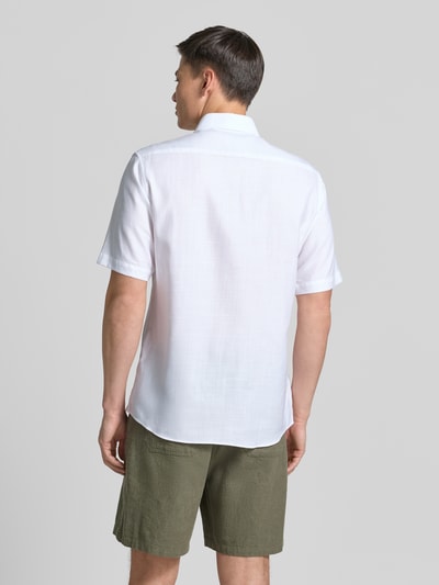 Männermodel trägt Modern Fit Business-Hemd mit Kentkragen von ETERNA aus Baumwoll-Lyocell-Mix, 1/2-Arm, weiße Farbe, Ganzkörperansicht Rückansicht.