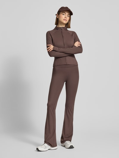 Frauenmodel trägt Flared Fit Leggings mit breitem Bund Modell 'Yoga' von Gina Tricot in Braunton, elastischer Material-Mix, Ganzkörperansicht von vorne.