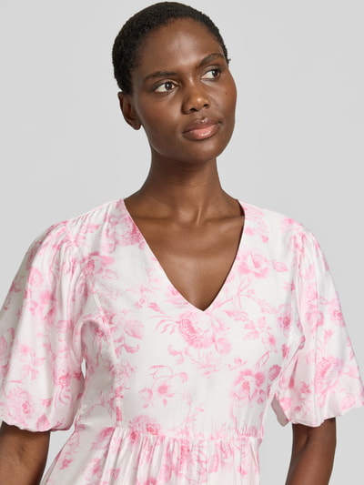Frauenmodel trägt tailliertes Freizeitkleid aus Viskose-Mix Modell 'BLISS' von Vero Moda, Optik:Allover-Muster, V-Ausschnitt, Ballonärmel, feine Webstruktur, Nahaufnahme Oberkörper