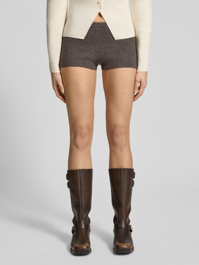 Vrouwenmodel draagt Slim Fit Shorts met wol-aandeel in tricotlook van Gina Tricot, materiaalmix, elastische band, ganzebodyvoorzijde.