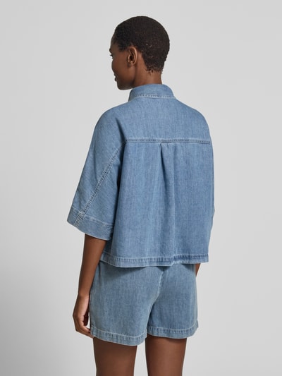 Vrouwenmodel draagt Relaxed Fit jeansblouse met borstzak model 'Fyndra' van OPUS in puur katoen, lichtblauw, overhemdkraag, knoopsluiting, ruglengte maat 36: 55 cm, mouwlengte maat 36: 15 cm, textuur van denim, geheel vanaf de achterkant.