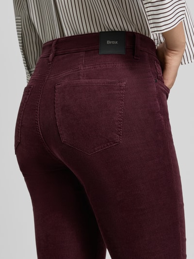 Frauenmodel trägt Schmale Hose aus Baumwoll-Mix Modell 'MARY' von Brax in Dunkelrot mit feiner Rippenstruktur, Nahaufnahme Rückansicht, Damen Schmale Hose von Brax.