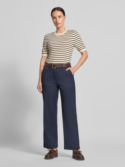 Frauenmodel trägt Regular Fit Chino aus Baumwoll-Lyocell-Mix von Marc O'Polo in Dunkelblau, kombiniert mit gestreiftem Shirt, Ganzkörperansicht von vorne, Damen Chino von Marc O'Polo.