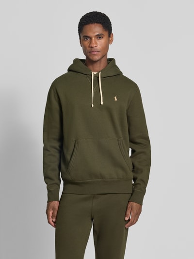 Männermodel trägt Regular Fit Hoodie aus Baumwoll-Mix von Polo Ralph Lauren in Olivgrün mit Kängurutasche, Ganzkörperansicht von vorne. Herren Hoodie von Polo Ralph Lauren