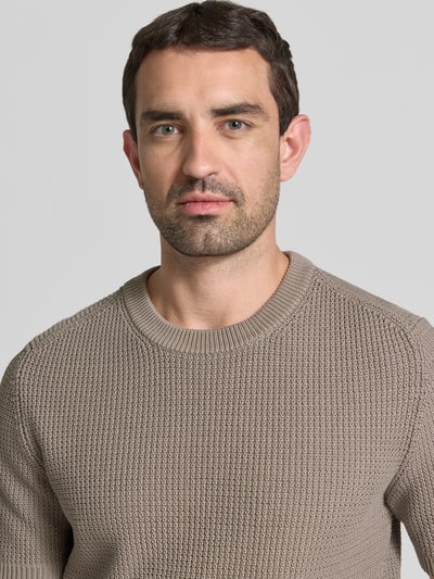 Männermodel trägt Relaxed Fit Strickpullover aus reiner Baumwolle Modell 'SAFFON' von HUGO, Waffelstrick, unifarben, Nahaufnahme Oberkörper.
