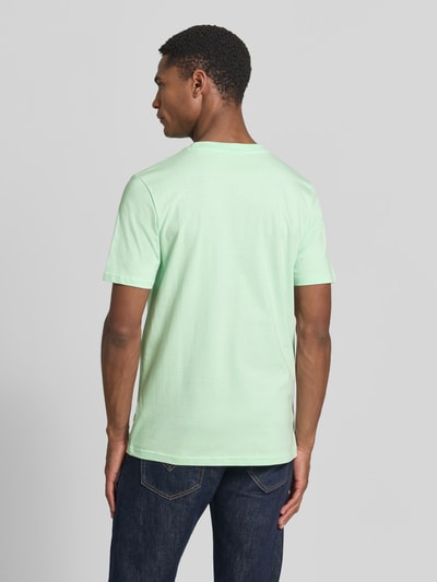 Männermodel trägt T-Shirt mit Stitching und Rundhalsausschnitt von Lindbergh in Mint, Slim-Fit, Reine Baumwolle, Rückenlänge 71 cm, Ganzkörperansicht Rückansicht.