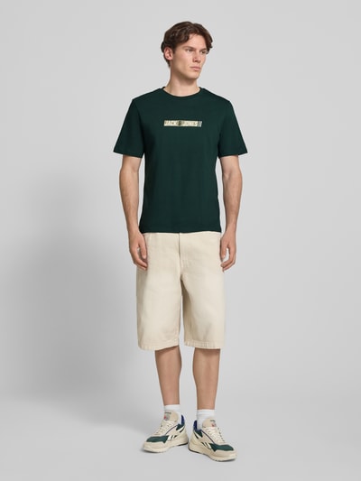 Mannelijk model draagt Regular Fit T-shirt met logoprint model 'Munk' van JACK & JONES, puur katoen, ruglengte maat M 74 cm, ganzebody vooraanzicht.