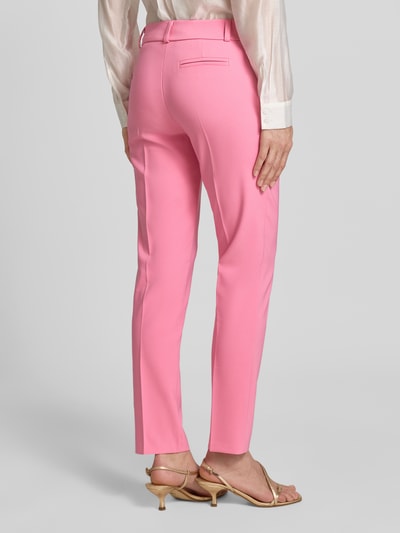 Frauenmodel trägt Stoffhose mit Bügelfalte Modell 'REWI' von Rinascimento in Slim Fit, rosa Material-Mix, Rückansicht Ganzkörperansicht.