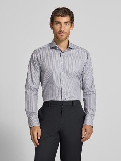 Männermodel trägt Regular Fit Business-Hemd aus Baumwolle von Christian Berg Men mit feinen Streifen, Haifischkragen, Ganzkörperansicht von vorne. Rückenlänge 82 cm, Schulterbreite 42 cm, Ärmellänge 65 cm.