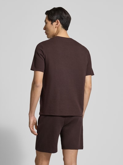 Männermodel trägt Regular Fit Pyjama-Oberteil aus Baumwoll-Mix Modell 'WAFFLE' von BOSS in Braun, strukturierte Piqué-Optik, unifarben, Ganzkörperansicht Rückansicht.