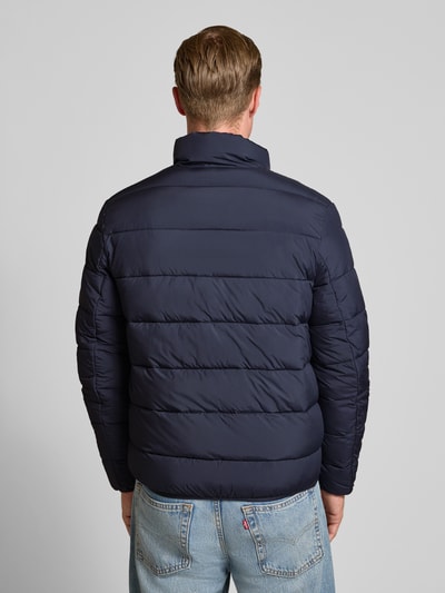 Männermodel trägt Regular Fit Steppjacke mit Stehkragen von Tom Tailor Denim in Dunkelblau, glatte Textur, Ganzkörperansicht Rückansicht, Herren Daunenjacke von Tom Tailor Denim.