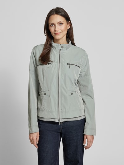 Kobiece modelka nosi Jacke mit Zweiwege-Reißverschluss od Amber & June w kolorze jasnoszarym, krój regular fit, stójka, kieszenie na piersi z zamkiem, kieszenie na guziki, długość tyłu w rozmiarze 36: 56 cm, szerokość ramion: 42 cm, szerokość w rozmiarze 36: 51 cm, długość rękawa: 60 cm, gładka tekstura, widok całej sylwetki z przodu.