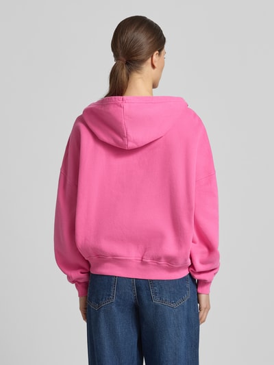 Frauenmodel trägt Hoodie mit Känguru-Tasche Modell 'PLIZZY' von American Vintage aus reiner bawełna, krój relaxed fit, logo, kieszeń kangurka, widok całej sylwetki od tyłu