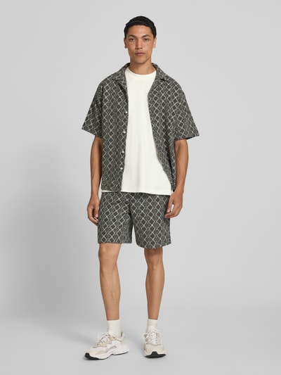 Männermodel trägt Relaxed Fit T-Shirt aus reiner Baumwolle von Marc O'Polo Denim in Weiß, kombiniert zu gemusterten Shorts, Ganzkörperansicht von vorne. Herren T-Shirt von Marc O'Polo Denim.