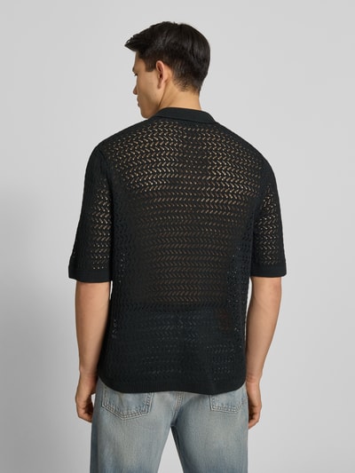Männermodel trägt Regular Fit Poloshirt aus Baumwoll-Mix Modell 'NYLE' von Only & Sons, schwarze Strickstruktur, Ganzkörperansicht Rückansicht.