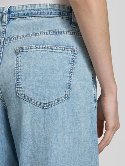 Kobieta nosi Regular Fit Wide Leg Jeans aus reiner Baumwolle Modell 'AISA' od Vero Moda, stylizowana na denim, splot twill, 5 kieszeni, zapięcie na guzik i ukryty zamek błyskawiczny, wykończenie: bawełna, detal szlufek na pasek, zbliżenie na tylne kieszenie, detailaufnahme.