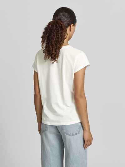 Frauenmodel trägt Regular Fit T-Shirt aus Viskose-Mix mit Statement-Print von Christian Berg Woman, helle Farbe, glatte Textur, Jeans, Ganzkörperansicht Rückansicht.