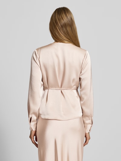 Frauenmodel trägt Wickelbluse aus Satin Modell 'Caprina' von Neo Noir, taillierter Schnitt, zartrosa, glatte Textur, Ganzkörperansicht Rückansicht.