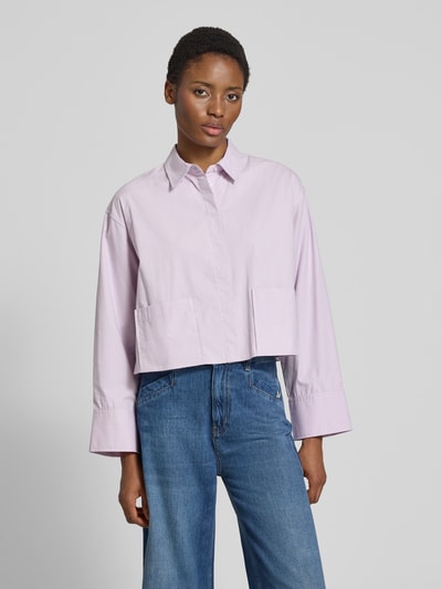 Vrouwenmodel draagt Relaxed fit overhemdblouse uit puur katoen Model 'Lee' van YAS in lichtpaars met opgestikte zakken, knoopsluiting, overhemdkraag, lange mouwen, gladde textuur, ruglengte maat 36: 50 cm, mouwlengte maat 36: 55 cm, voorkant geheel zichtbaar, opname van voren